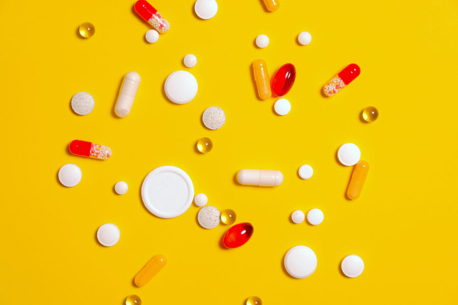 Medication pills on yellow surface